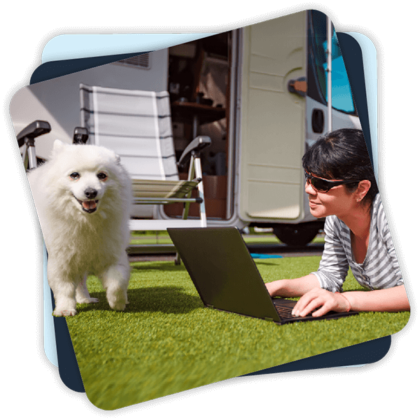 Woman with Laptop and Dog outside her Campervan