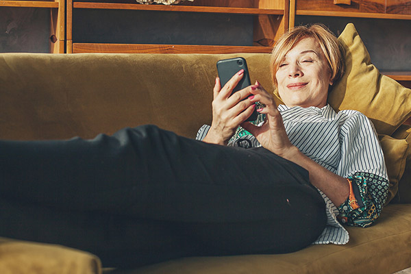Older Person using Mobile Phone setting up her Funeral Expenses Insurance